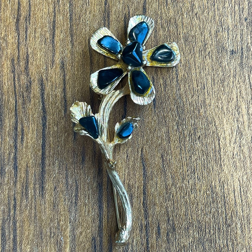 SWABODA flower brooch. An all black gem flower surrounded by gold tones.